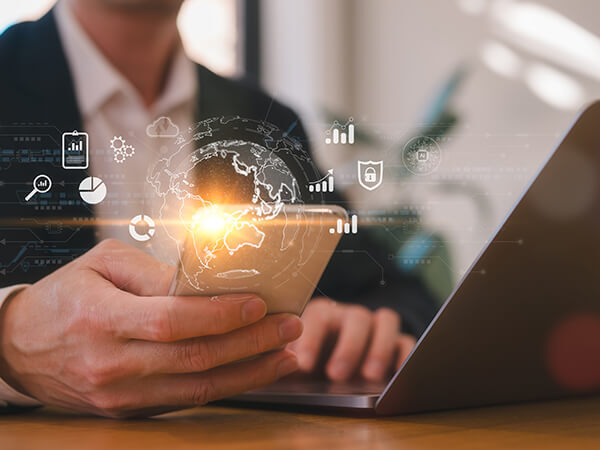 Man looking at mobile phone while also on laptop