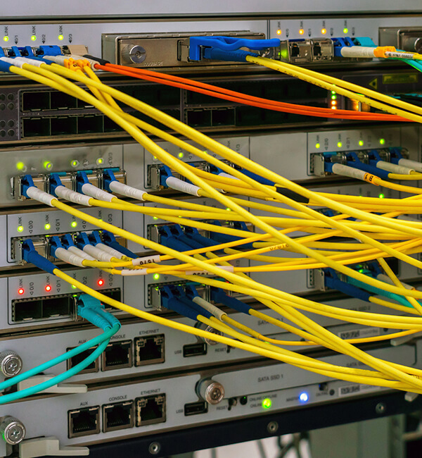 A bunch of cable wires plugged into backend of equipment
