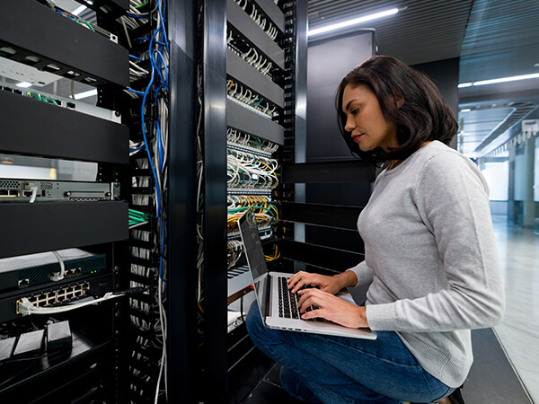 Woman in data center facility typing on a keyboard