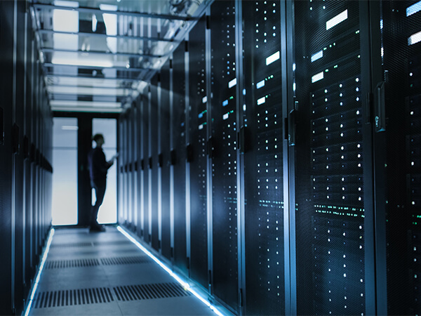 Data center technician looking at rack in a data center