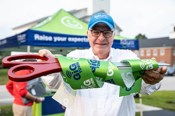 Man holding up scissors for ribbon cutting