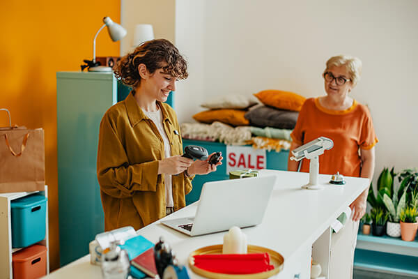 Retail small business setting with woman behind counter helping customer