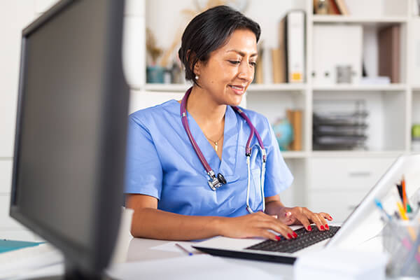 Medical worker typing on a laptop