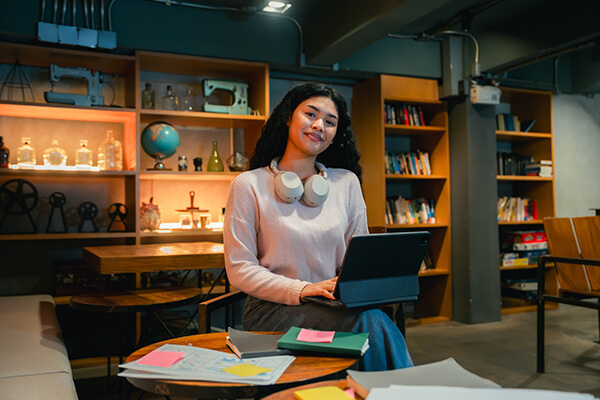College student working on laptop in a library setting