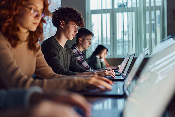 Students working on laptops in library