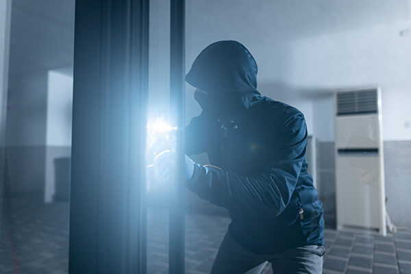 Business Security Compliance Sub Hero 600x400 Robber looking through office building with a flashlight