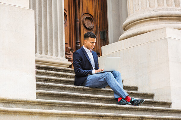 Man sitting on stairs in front of government building