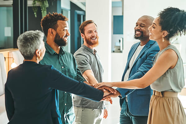 Team of employees putting hands together in the middle