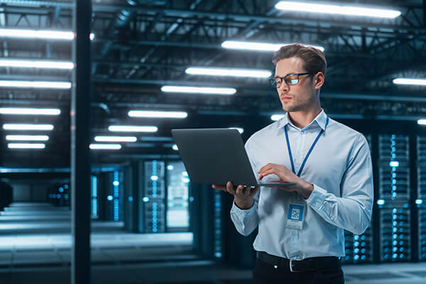 Man working on laptop in a data center facility