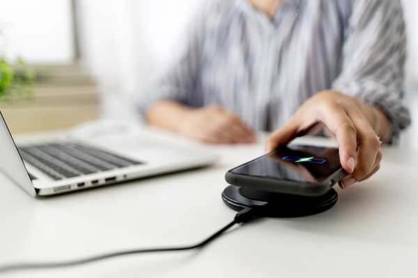 Wholesale Network Changes Notices Sub Hero 600x400 Person charging phone at desk