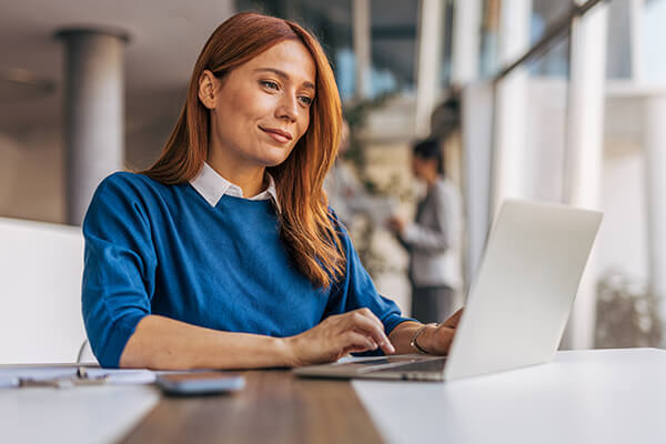 Wholesale Systems E Bonding Sub Hero 600x400 Woman sitting and typing on laptop