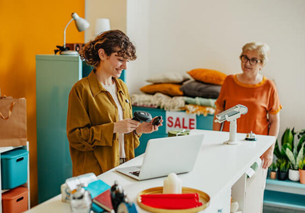 Retail small business setting with woman behind counter helping customer
