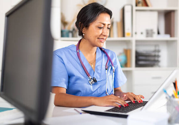 Medical worker typing on a laptop
