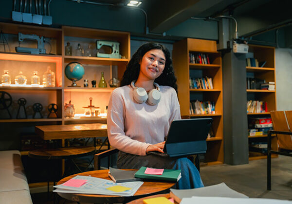 College student working on laptop in a library setting
