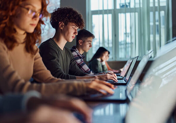 Students working on laptops in library