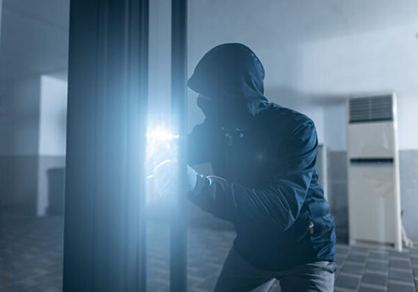 Business Security Compliance Sub Hero 600x400 Robber looking through office building with a flashlight