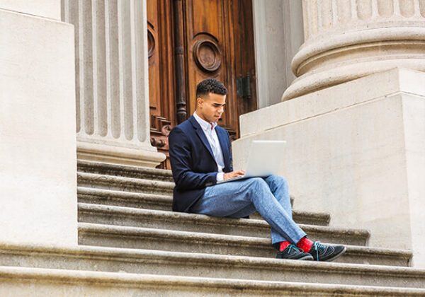 Man sitting on stairs in front of government building
