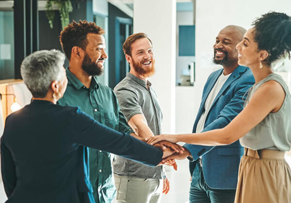 Team of employees putting hands together in the middle