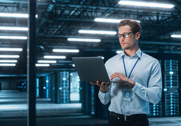 Man working on laptop in a data center facility