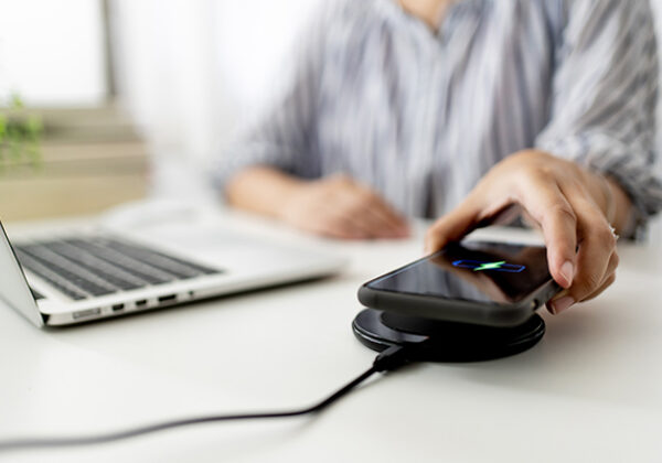 Wholesale Network Changes Notices Sub Hero 600x400 Person charging phone at desk