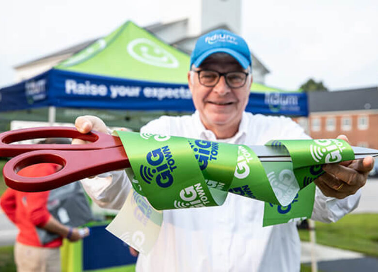 Man holding up scissors for ribbon cutting