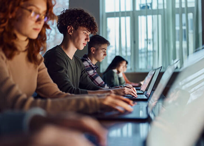 Students working on laptops in library