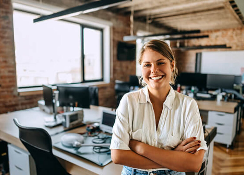 Woman posing for camera in front of her desk