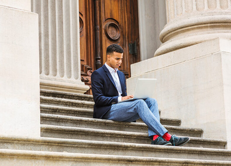 Man sitting on stairs in front of government building