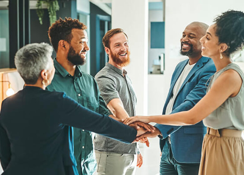Team of employees putting hands together in the middle