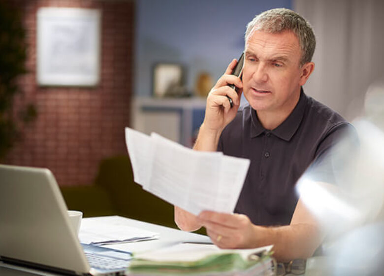 Man on phone looking at paperwork