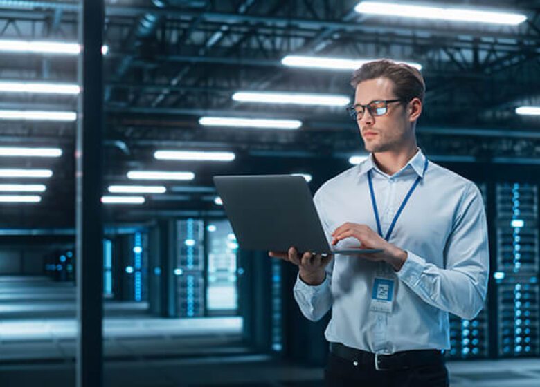 Man working on laptop in a data center facility